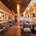 Thumbnail of http://Elegant%20restaurant%20interior%20with%20warm%20neutral%20design,%20natural%20wood%20dining%20tables%20and%20chairs,%20golden%20amber%20walls,%20soft%20ambient%20lighting,%20large%20windows%20with%20natural%20light,%20comfortable%20seating,%20earthy%20colour%20scheme,%20and%20modern%20rustic%20aesthetic%20in%20Dulwich