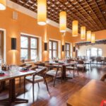 Thumbnail of http://Warm%20neutral%20restaurant%20interior%20featuring%20earthy%20colour%20scheme%20with%20golden%20amber%20walls,%20natural%20wood%20dining%20tables%20and%20chairs,%20large%20windows%20with%20natural%20light,%20soft%20warm%20lighting%20fixtures,%20rustic%20design%20elements,%20comfortable%20seating,%20and%20cosy%20restaurant%20decor%20in%20Dulwich