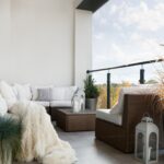 Thumbnail of http://Light-filled%20boho%20balcony%20in%20Caterham%20with%20rattan%20corner%20sofa,%20soft%20throw,%20and%20potted%20grasses.