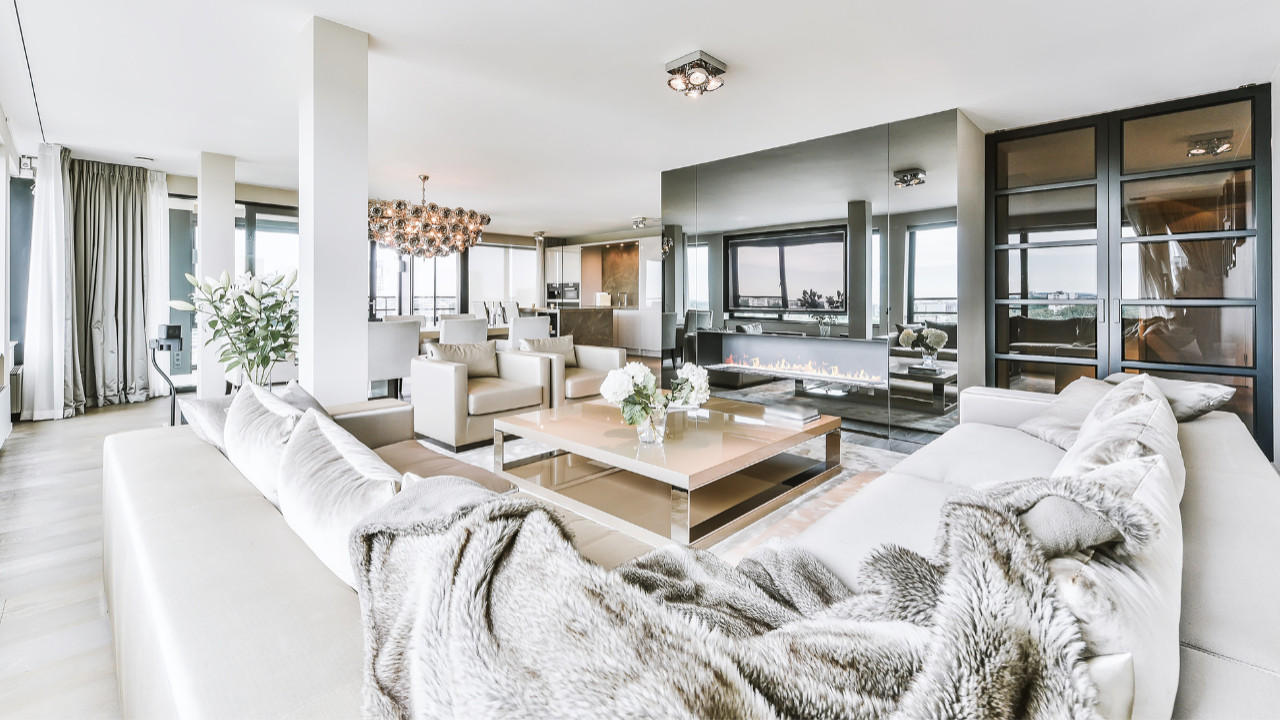 Comprehensive residential transformation with premium marble and stone materials throughout spaces, designer contemporary furnishings including seating and tables, elegant neutral color palette with warm undertones, expert craftsmanship in custom cabinetry and millwork, functional beautiful kitchen with marble surfaces and black cabinets, professional lighting design with multiple fixture types, luxurious bathroom with statement freestanding tub, natural wood feature walls with linear detailing, abundant window glazing with natural light, integrated storage solutions with clean lines, luxury appliances and designer fixtures, restful bedroom with upholstered bed and integrated lighting, open-plan living with flowing spaces, metallic gold and bronze decorative accents, live plants and greenery throughout, modern furniture with sleek designs, thoughtful material choices across rooms, designated workspace areas, and professional interior design consultation through installation in Kensington