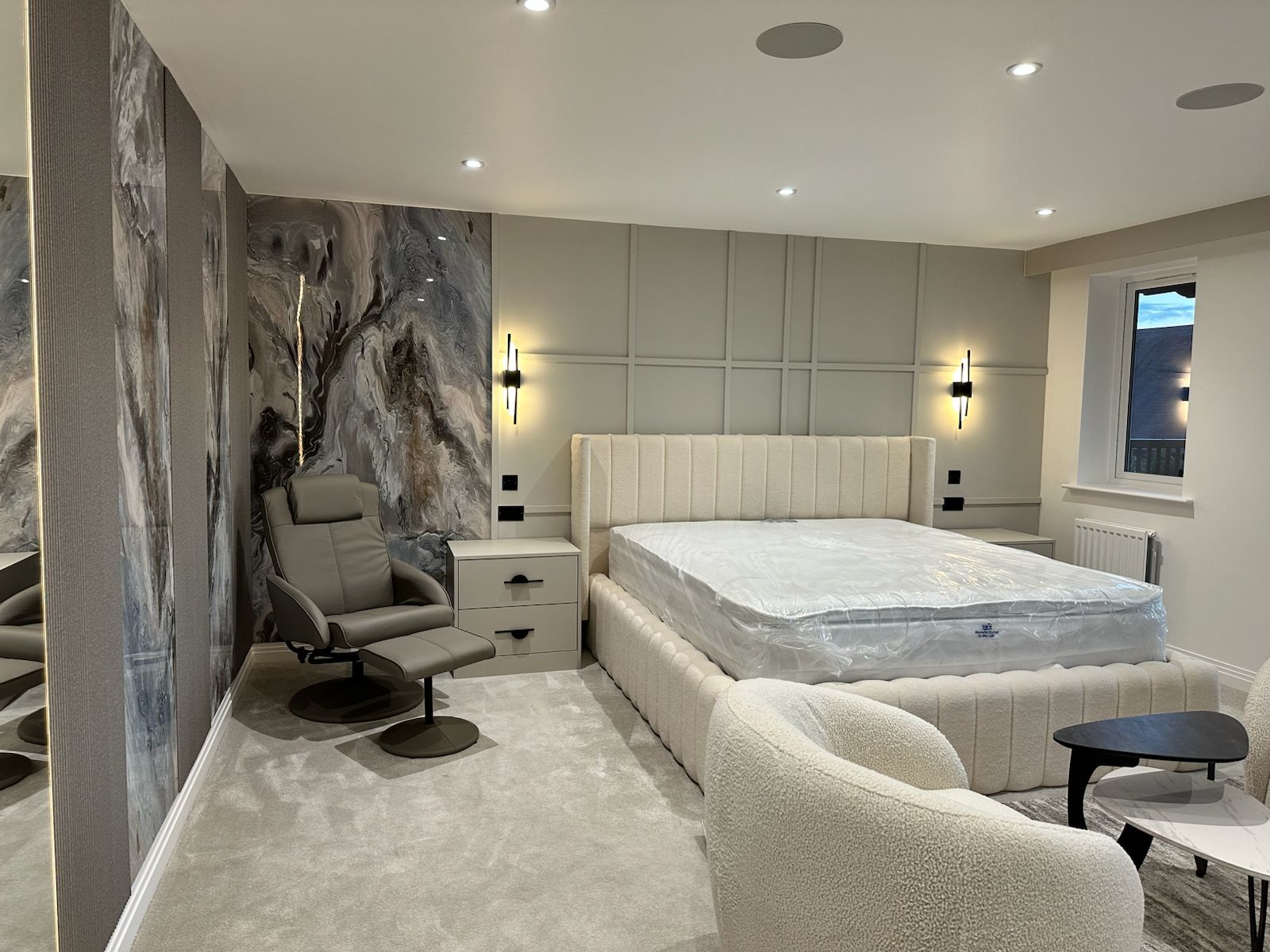 Soft neutral luxury bedroom with sculptural furniture and upholstered finishes in London