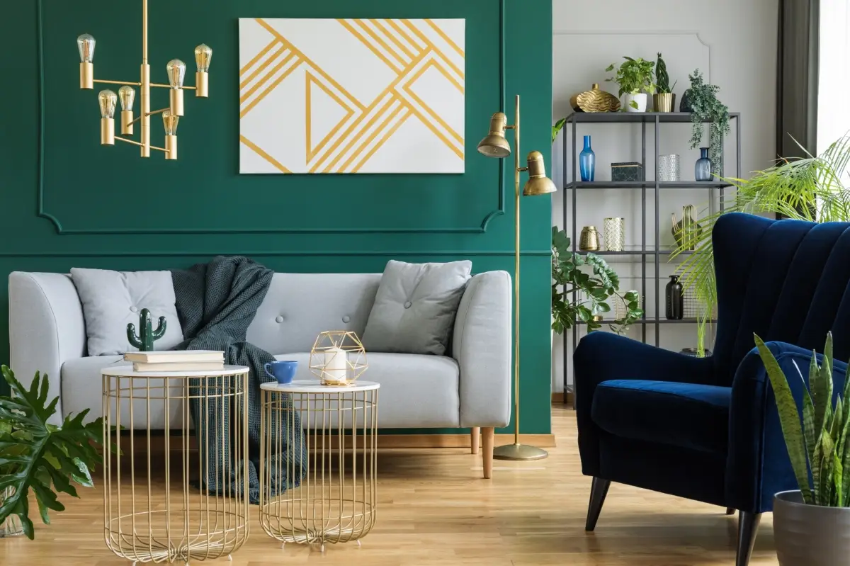 A stylish and modern home interior design in London by Oraanj Interior Design, featuring a cosy grey sofa, deep blue armchair, and elegant gold accents.